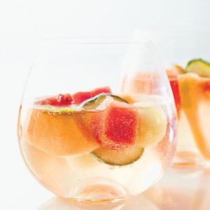Piece of cut melon inside a glass of sparkling water
