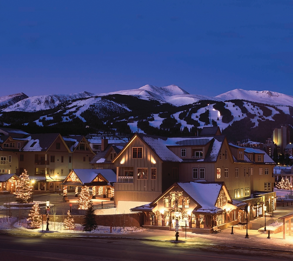 Buildings in front of the Colorado mountains at dusk
