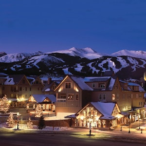Buildings in front of the Colorado mountains at dusk

