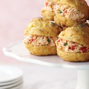 Smoked salmon salad is served on cream puff pastry buns with cheddar cheese and poppy seeds
