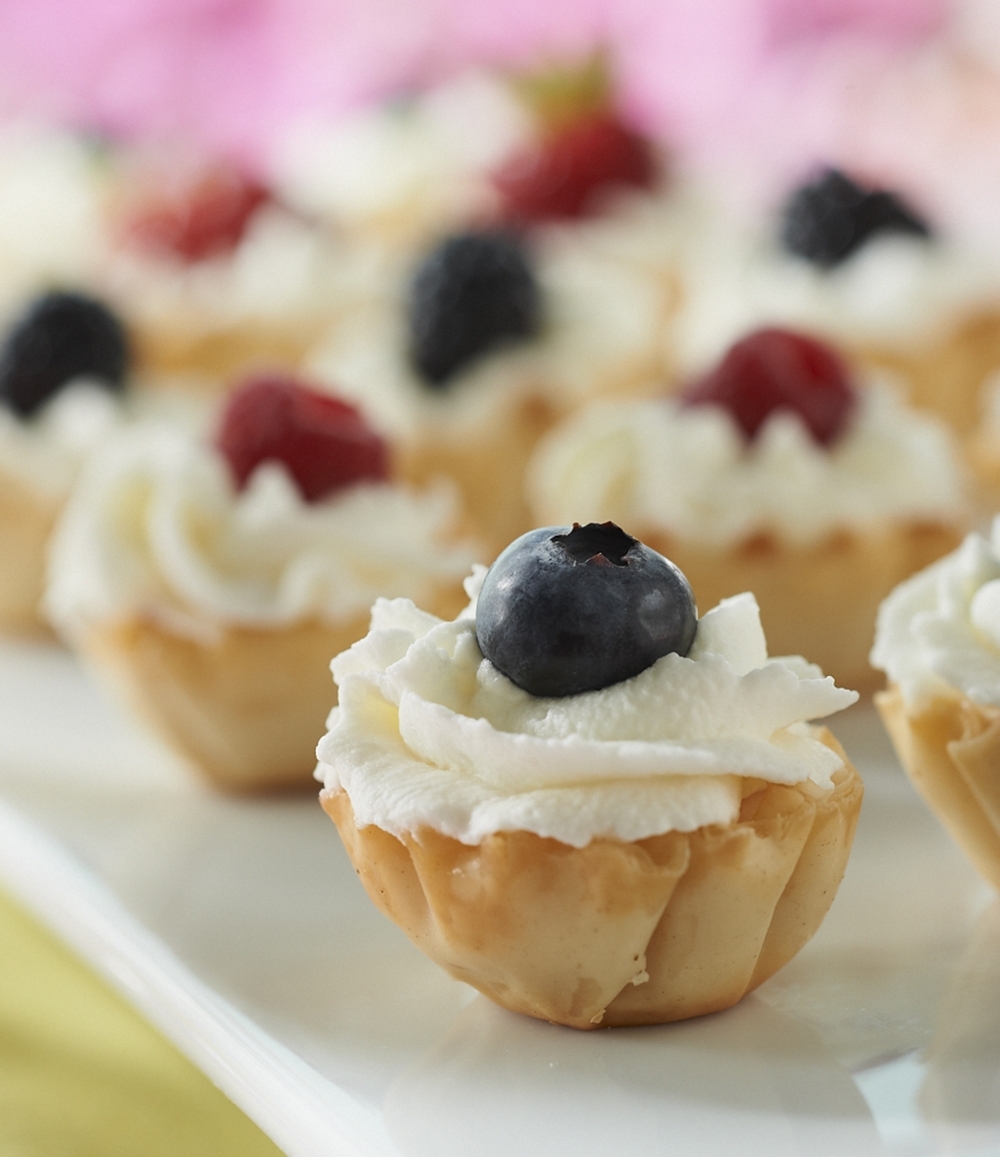 Berry Tarts are filled with a mix of yogurt, whipped topping and heavy whipping cream, then topped with assorted berries.
