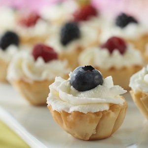 Berry Tarts are filled with a mix of yogurt, whipped topping and heavy whipping cream, then topped with assorted berries.
