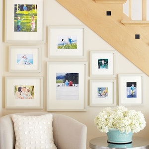 A gallery wall displays photos in the space under a staircase.

