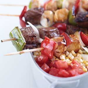 Skewers of marinated chicken, steak, and vegetables are easy for guests to handle at a casual al fresco dinner.
