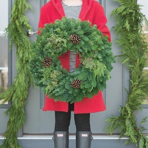 A doorway draped with fresh western red cedar garland sends a festive nod to the neighborhood. To finish the holiday look for your door, add a noble fir wreath highlighted by juniper with berries and ponderosa pine cones. For more color, add artificial berries, weatherproof ornaments and ribbon.
